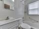 Well-lit white tiled bathroom featuring a shower-tub combo and a functional vanity with a sink at 620 S Irvington Ave, Indianapolis, IN 46219