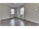 A bedroom featuring hardwood floors, two windows, and light walls, offering a cozy and bright space at 620 S Irvington Ave, Indianapolis, IN 46219