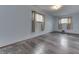 Bedroom with wood-look floors and light-blue walls, complemented by natural light from two windows at 620 S Irvington Ave, Indianapolis, IN 46219