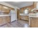 Well-lit kitchen featuring laminate floors, white appliances, and wooden cabinets at 620 S Irvington Ave, Indianapolis, IN 46219