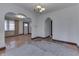 Spacious living room featuring hardwood floors, arched doorways, and a vintage chandelier at 620 S Irvington Ave, Indianapolis, IN 46219