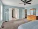 Open bedroom with neutral carpet, ceiling fan, and access to a bathroom and laundry room at 6650 W Black Tail Way, McCordsville, IN 46055
