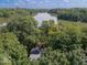 Aerial view of mature trees surrounding a home and lake in the background at 7037 Indian Lake W Blvd, Indianapolis, IN 46236
