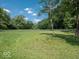 Expansive backyard featuring a well-maintained lawn and mature trees creating a park-like setting at 7037 Indian Lake W Blvd, Indianapolis, IN 46236