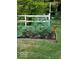 A flourishing raised garden bed featuring vibrant flowers and lush plants, set against a white picket fence at 7037 Indian Lake W Blvd, Indianapolis, IN 46236