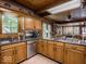 Spacious kitchen features updated appliances, granite counters, wooden cabinets, and tiled floor at 7037 Indian Lake W Blvd, Indianapolis, IN 46236