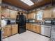 Spacious kitchen features updated appliances, granite counters, wooden cabinets, and tiled floor at 7037 Indian Lake W Blvd, Indianapolis, IN 46236
