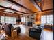 Inviting living room with wood paneled vaulted ceilings, exposed beams, and a stone fireplace at 7037 Indian Lake W Blvd, Indianapolis, IN 46236