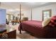 Bright main bedroom with four-poster bed, wood trim windows, and access to the backyard at 7037 Indian Lake W Blvd, Indianapolis, IN 46236
