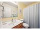 Well-lit bathroom featuring a vanity, mirror, toilet, and a shower with blue striped curtain at 715 Stockbridge Dr, Westfield, IN 46074