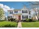 Charming two-story white home with a red door, American flag, and well-maintained landscaping at 715 Stockbridge Dr, Westfield, IN 46074