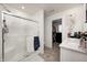Modern bathroom with a glass-enclosed shower, a bright vanity, and a glimpse into the walk-in closet at 7239 Governors Row, Avon, IN 46123