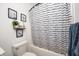 Cozy bathroom featuring a shower with a stylish black and white striped curtain and wall art at 7239 Governors Row, Avon, IN 46123