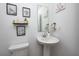 Clean powder room with pedestal sink, framed art, and modern fixtures for a touch of style at 7239 Governors Row, Avon, IN 46123