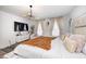 Bright bedroom featuring a cozy chair, television, natural light, and a large modern bed with decorative pillows at 7239 Governors Row, Avon, IN 46123