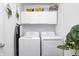 Clean laundry room with modern white washer and dryer units and white cabinets for storage at 7239 Governors Row, Avon, IN 46123