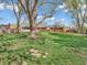 Backyard featuring mature trees, green grass, and a red brick home with a screened porch, ideal for relaxation at 7671 Sherry Ln, Brownsburg, IN 46112