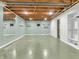 Spacious basement features exposed ceiling, painted concrete floor, and mirror on wall at 7671 Sherry Ln, Brownsburg, IN 46112