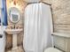 Charming bathroom features a pedestal sink, oval mirror, and neutral tile surround in the shower area at 7671 Sherry Ln, Brownsburg, IN 46112