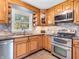 An efficient kitchen features stainless steel appliances, granite countertops, and custom light brown cabinetry at 7671 Sherry Ln, Brownsburg, IN 46112