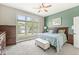 A bedroom with green accent wall, ceiling fan, large windows, and bedside tables at 768 Grace Ct, Carmel, IN 46032