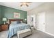 A bedroom with green accent wall, ceiling fan, and an ensuite bathroom at 768 Grace Ct, Carmel, IN 46032