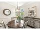 Cozy dining area features a round table, stylish chandelier, and buffet with decorative accents near bright windows at 768 Grace Ct, Carmel, IN 46032