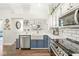 Updated kitchen with white subway tile, blue cabinets, stainless steel appliances and view to dining area at 768 Grace Ct, Carmel, IN 46032