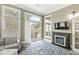 Bright living room with large windows, a cozy fireplace, and a sliding glass door to the deck at 768 Grace Ct, Carmel, IN 46032