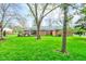 Large backyard with mature trees, green grass, and patio of brick home at 7756 N Audubon Rd, Indianapolis, IN 46250