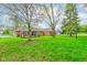 View of the home's backyard featuring well-manicured lawn and a wooden porch perfect for relaxing at 7756 N Audubon Rd, Indianapolis, IN 46250
