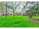 Expansive backyard featuring lush green grass, mature trees, and partial view of the brick home at 7756 N Audubon Rd, Indianapolis, IN 46250