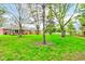 The large backyard features mature trees, a green lawn, and a brick home with a wooden porch at 7756 N Audubon Rd, Indianapolis, IN 46250