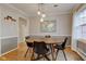 Bright dining area with round table, modern pendant lighting, and natural light from the adjacent window at 7756 N Audubon Rd, Indianapolis, IN 46250