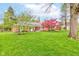 Beautiful brick home with a vibrant red Japanese maple tree and a well-manicured green lawn at 7756 N Audubon Rd, Indianapolis, IN 46250