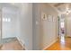 Bright hallway with hardwood floors and views of the front door and a living area at 7756 N Audubon Rd, Indianapolis, IN 46250