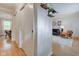 Hallway with hardwood floors, white walls, and view into a living room and dining area at 7756 N Audubon Rd, Indianapolis, IN 46250