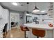 Modern kitchen with white cabinets, breakfast bar seating, stainless steel appliances, and open layout at 7756 N Audubon Rd, Indianapolis, IN 46250