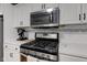Kitchen featuring stainless steel appliances, a gas range, and white cabinetry at 7756 N Audubon Rd, Indianapolis, IN 46250