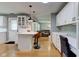 Open concept kitchen with white cabinets, breakfast bar, and seamless flow to the living areas at 7756 N Audubon Rd, Indianapolis, IN 46250
