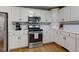 Well-lit kitchen with white cabinetry, stainless steel appliances and hardwood floors at 7756 N Audubon Rd, Indianapolis, IN 46250
