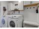 Bright laundry room with white cabinets, wooden accents, and modern appliances at 7756 N Audubon Rd, Indianapolis, IN 46250