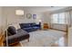 Comfortable living room with large blue sofa, decorative pillows, and natural light from the big window at 7756 N Audubon Rd, Indianapolis, IN 46250