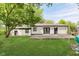 A large backyard features a wood deck, lush green lawn, mature trees, and the home exterior at 8041 Barry Rd, Indianapolis, IN 46219