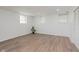 A finished basement with neutral paint, wood-look flooring, and natural light from three windows at 8041 Barry Rd, Indianapolis, IN 46219