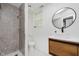 Bathroom with modern wood cabinet, granite shower, and a contemporary round mirror at 8041 Barry Rd, Indianapolis, IN 46219