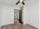 Bedroom featuring wood-look floors, white walls, ceiling fan, open door, and a view into the closet at 8041 Barry Rd, Indianapolis, IN 46219