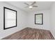 Bedroom showcasing wood-look floors, white walls, a ceiling fan, and natural light from two windows at 8041 Barry Rd, Indianapolis, IN 46219