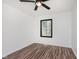 A clean and simple bedroom with wood-look floors, white walls, a ceiling fan, and a window at 8041 Barry Rd, Indianapolis, IN 46219