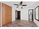 A bedroom with wood-look floors, a ceiling fan, closet, and a view into the ensuite bathroom at 8041 Barry Rd, Indianapolis, IN 46219